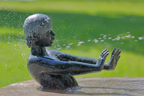 Fountain with sculpture by Günter Kaden 2001, child with outstretched arms to block water jet,