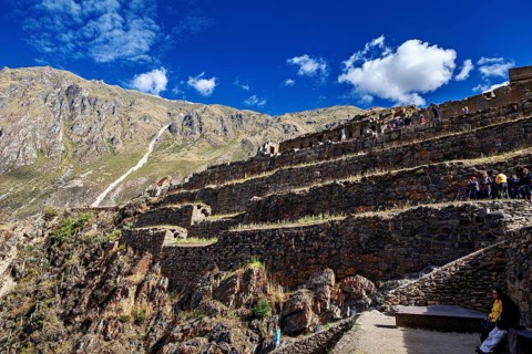 Inca ruins with terraces in a steep mountain landscape under blue skies, The Inca ruins of