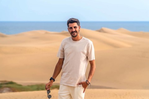 Young man enjoying a summer vacation amidst the stunning desert landscape of maspalomas dunes,