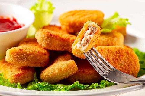 Fried chicken breast nuggets, on lettuce leaves, with tomato sauce, horizontal, no people,