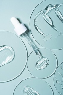 Top view of transparent gel smears and pipettes on laboratory glass plates. The smooth blue
