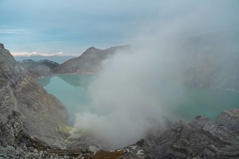 Mist rises from the Ijen volcano's sulfuric crater lake in Indonesia, creating an otherworldly