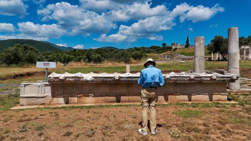 Temple of Messene, A man standing in front of an archaeological structure in sunny sky, ancient