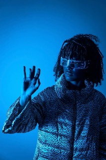Young programmer wearing transparent augmented reality glasses is using holographic interface,