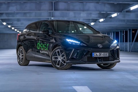 Black car in an illuminated multi-storey car park at night, e-car sharing, Deer Mobility, MG4,