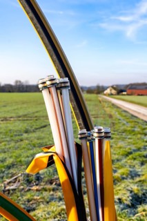 Fibre optic connection, empty conduits protrude from the ground along a dirt track, into which the