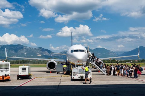 TIRANA, ALBANIA - JULY 3, 2026: Passengers boarding commercial passenger aircraft on airport apron,