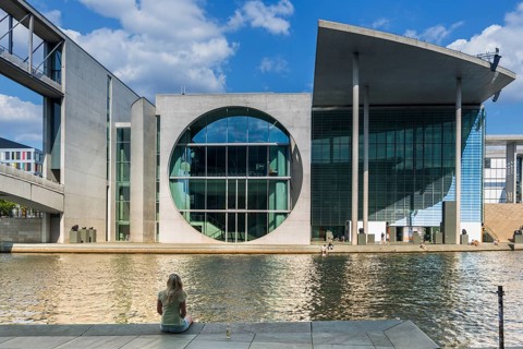Woman sitting in the sun on the banks of the Spree at Marie-Elisabeth-Lüders-Haus in the government