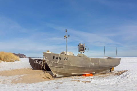 Fishing boats on snow covered beach in winter along the Baltic Sea at Baabe, Mönchgut peninsula,