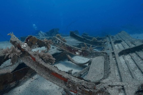Underwater view of ship fragments covered with sand on the seabed, meteor wreck dive site, Russian