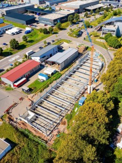 Aerial view of an industrial building with crane and various buildings in an urban area, Parkhaus