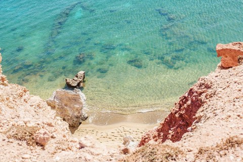 Scenic view of Paleochori Beach on Milos Island, Greece. Turquoise waters meet rocky cliffs and