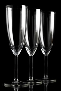Three empty champagne glasses against a black background