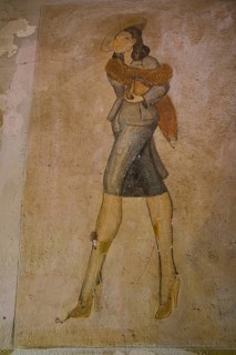 A chic woman in retro look with fur stole and heels, depicted on a faded wall painting, Lost Place,