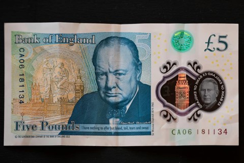 Close-up of a Bank of England five pound note featuring Sir Winston Churchill and the portrait of