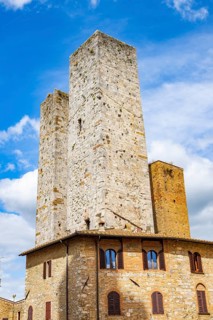 Towers of the old Town with historic buildings from Piazza del Duomo at San Gimignano on a sunny