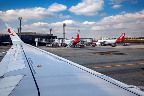 View from an airplane window with several airplanes at the terminal on a sunny day, airplanes on