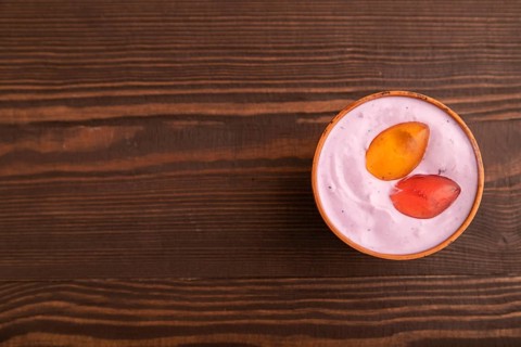 Purple Yogurt, with jelly candy on brown wooden background, top view, flat lay, copy space,