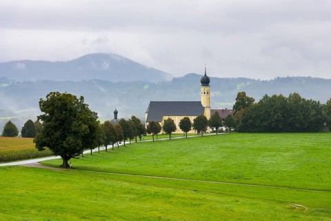 Pilgrimage church of St Marinus in Wilparting surrounded by green meadows and trees, under a