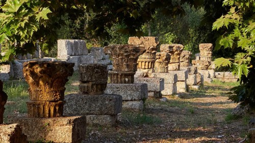 Column remains in an ancient ruined site, surrounded by shade and nature, Archaeological Site,