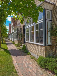 Historic row of houses with bay windows in Lange Strasse, gabled houses, footpath, trees, Arnis,
