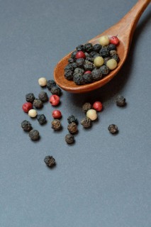 Pepper, various peppercorns in a wooden spoon