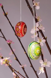 Blooming branches of a peach tree in a vase decorated with Easter eggs, spring, Germany