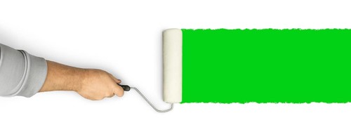 Male hand rolling paint roller over green screen background