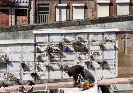 Cemitério da Lapa, Lapa cemetery, a person tending a burial ground, beyond the wall the houses of