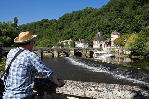 French man wearing a straw hat looking at the Dronne River, Brantôme, Dordogne department,