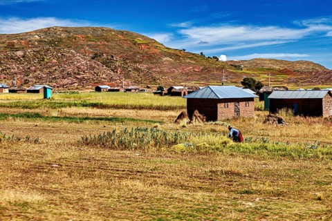 Farms in a hilly landscape with agriculture and a blue sky in the background, The villages and