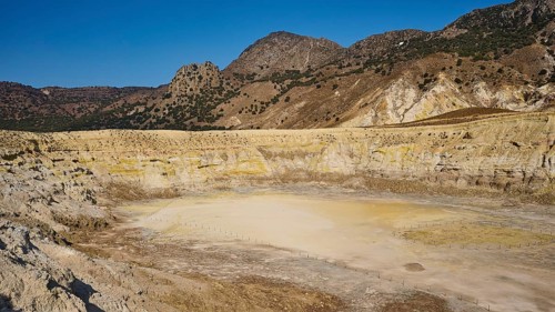 Large, dry volcanic crater surrounded by hilly mountain landscape, volcanism, volcanic island,