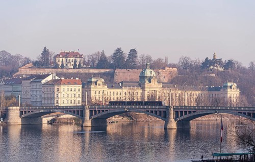A serene morning scene captures the historic essence of Prague, featuring the majestic cityscape