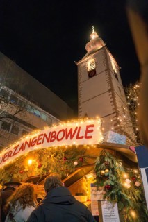 A Christmas market stall in front of an illuminated church at night, Christmas market, Nagold,