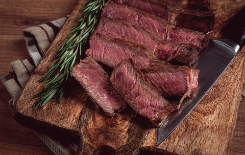 Fried steak, beef steak, rib eye steak, sliced steak, on a chopping board, top view, no people
