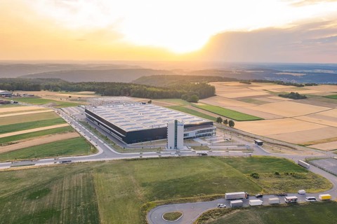 Large industrial plant nestled in vast fields at sunset, Eisberg, Nagold, Germany