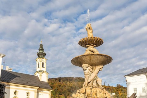 Residenzbrunnen am Residenzplatz, with the tower of St. Michael's Church in the background,