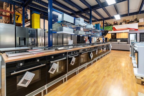 Appliance showroom offering a wide selection of modern ovens, hobs, and refrigerators for sale,