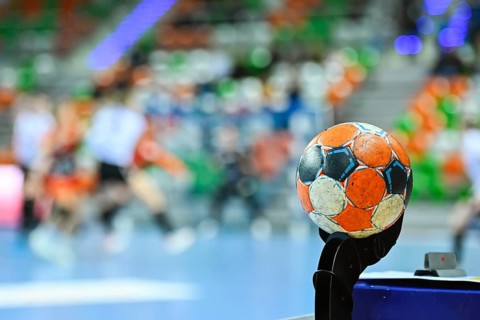 Handball ball and blurred match in the background.