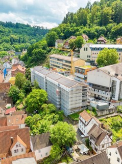 Urban landscape with construction crane and buildings in lush green surroundings, new PV plant at