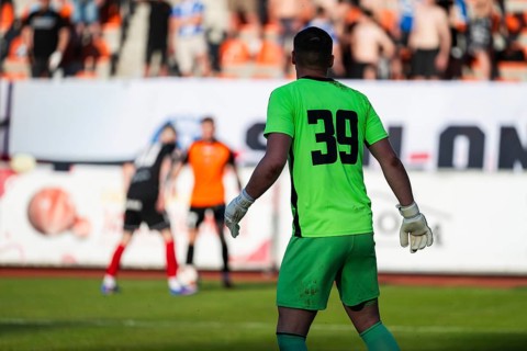 Goalkeeper in bright green uniform number 39 watching play during soccer match, real action moment