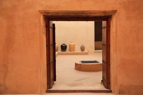 View through door opening of courtyard with jugs and minimalistic wall decoration, courtyard, Fort