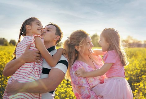 A family, mom, dad and two daughters are having fun together in nature. Family values