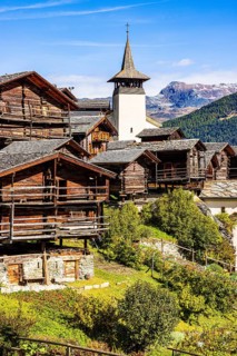 Old wooden houses and the Saint Theodule church in the historic village centre, Grimentz, Val