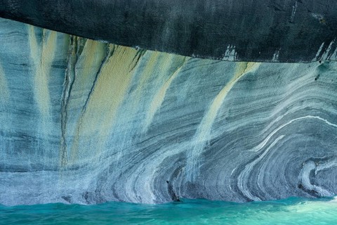 Marble wall with curved veins over turquoise-coloured water, marble caves (Capillas de Mármol),