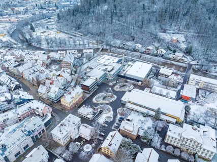 Snow-covered buildings and streets in a neighbourhood, seen from the air, quiet winter atmosphere,