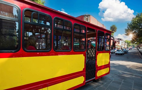 Tour Bus going on beautiful colonial and colorful Coyoacan Streets near Mexico City on city tour