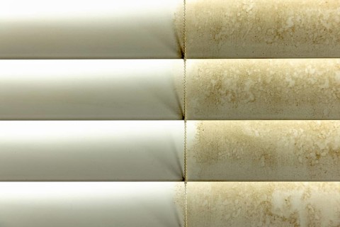 Residential window shades showing the before and after of a good cleaning, one side clean and one