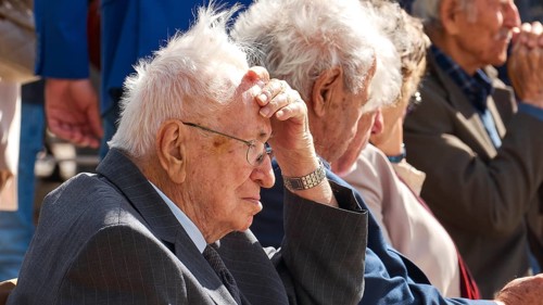 Survivors of the massacre of 3 June 1941, older men in suits sit thoughtfully in a predominantly
