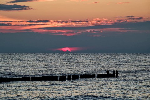 Sunset on the Baltic Sea beach, Wustrow beach in the evening light with clouds, evening mood,